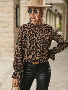 Detailed view of women's leopard print blouse with ruffle collar and cuffs on a model