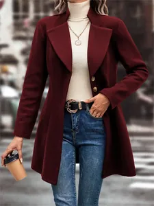 Detailed view of a burgundy lapel wool coat styled with a white turtleneck and jeans.