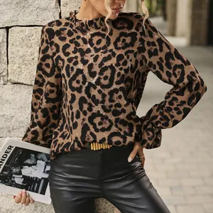 Detail of a leopard print long-sleeve blouse with a ruffled neckline and elastic cuffs.