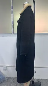 Gedetailleerd zijaanzicht van een lange zwarte denim jas met sherpa kraag op een mannequin