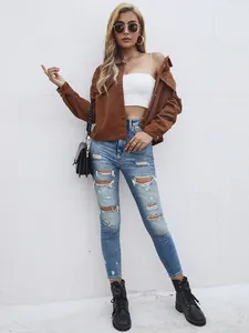 Vue de face d'une femme en veste en velours côtelé marron et jean bleu déchiré style urbain