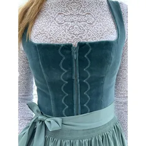 Close-up of elegant teal velvet Dirndl with lace sleeves and bow waist