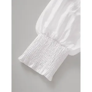 Detail macro view showing the white smocked elastic cuff of a lightweight woven dress