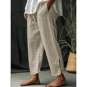 Detailed view of men's striped linen-style pants featuring unique buttoned split hem.