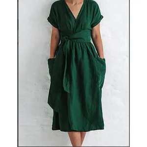 Close-up detail of dark green cotton linen dress featuring V-neckline and waist tie