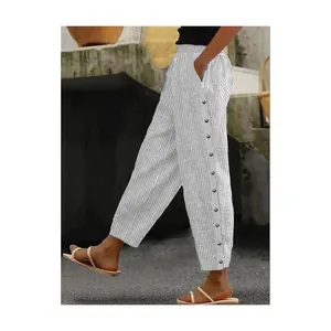 Detail of women's striped casual trousers featuring decorative side buttons and fabric texture