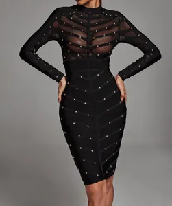 Close-up view of black bandage dress with sheer mesh panels and gold studded details