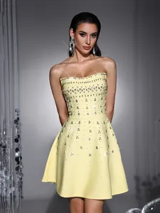 Detailed view of a yellow strapless cocktail dress with rhinestone and pearl embellishments