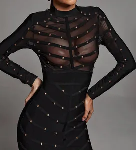 Close-up of black bandage dress with mesh sheer top and gold stud detailing