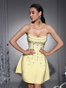 Detailed view of the yellow strapless dress bodice with heavy rhinestone crystals