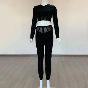 Vue frontale complète de l'ensemble noir deux pièces avec détails empiècements mesh.