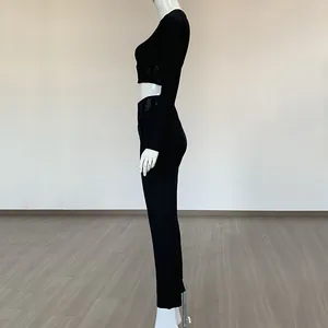 Vue latérale de l'ensemble deux pièces noir avec découpes en mesh et pantalon taille haute.
