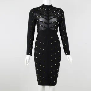 Close-up detail of a black long-sleeved bandage dress featuring gold studs and mesh
