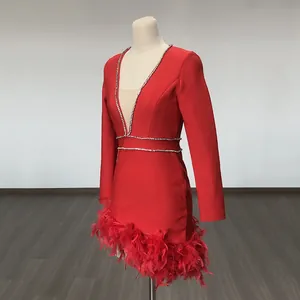 Detailed macro view of a red French mini dress with rhinestone V-neck and luxury feather hem