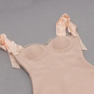 Dettaglio di un abito bandage color nudo con pizzo e spalline con fiocco di raso