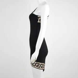 Side view of black one-shoulder bandage dress with cream Greek key pattern trim detail