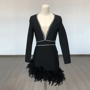 Detailed view of black bandage mini dress with deep V rhinestones and feather hem