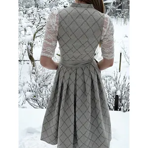 Detailansicht der Rückseite eines grauen Dirndls mit eleganten weißen Spitzenärmeln.