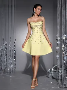 Detailed view of yellow strapless gala dress featuring heavy rhinestone embellishments