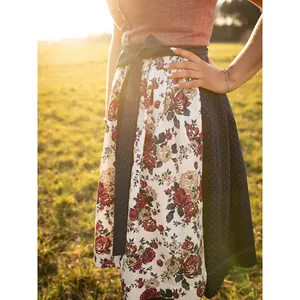 Detailansicht eines eleganten Oktoberfest-Dirndls mit Blumenmuster im Abendlicht.