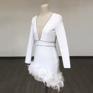White long sleeve bandage dress with deep V-neck, feather trim and rhinestone details