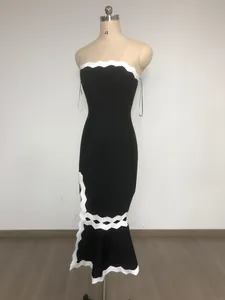 Dettaglio di un abito a sirena in stile Hepburn con bordo smerlato bianco e spacco laterale