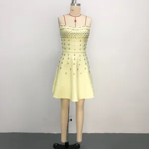 Elegant yellow mini gala dress with heavy beadwork and sequins on a tailor's mannequin