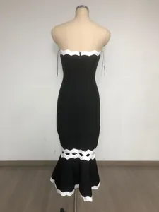 Elegante abito a sirena senza spalline bicolore nero e bianco con bordo ondulato e traforato