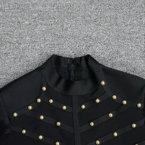 Detail view showing heavy gold studs and sheer mesh panels on a black bandage dress.