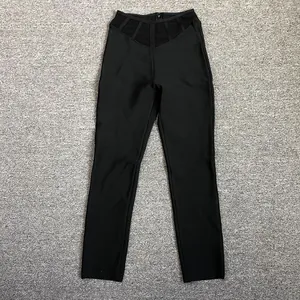 Vue détaillée d'un pantalon bandage noir à taille haute avec découpes en maille.