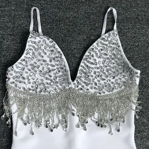 Detailed view of white bandage dress with rhinestone beaded bust and sparkling tassels