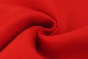 Detailed macro shot of premium red scuba fabric texture showing soft elegant folds