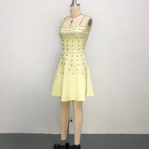 Detail view of a yellow bandage mini dress with sparkling rhinestone embellishments.
