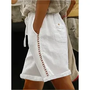 Detailed close-up of women's white leisure shorts featuring hollow lace side stitching.