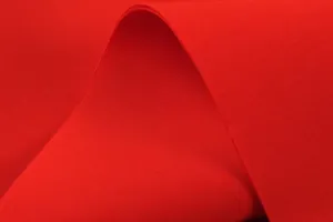 Close-up view of red space cotton fabric showing texture for elegant dress.