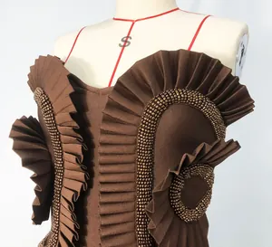 Close-up of brown bandage dress featuring pleated ruffles and hand-beaded trim details