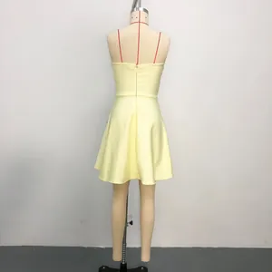 Detailed back view of an elegant pale yellow sleeveless evening dress on a tailor mannequin