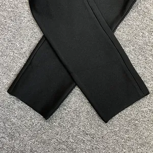 Détail des bas de pantalon noir à taille haute nervuré montrant la texture du tissu.