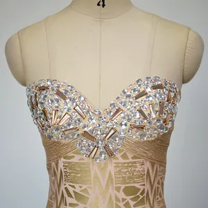 Detail of luxury rhinestone embellished bandage tube dress with gold foil pattern for party.