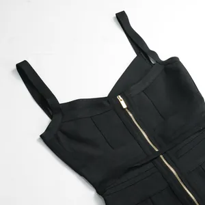 Close-up detail of a black bandage jumpsuit featuring a gold front zipper and V-neckline straps