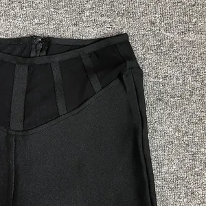 Détail macro d'un pantalon bandage noir à taille haute avec découpes en mesh élégantes