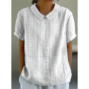 Close-up of white short-sleeved blouse with eyelet embroidery and Peter Pan collar