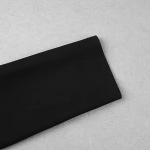 Gros plan sur le tissu noir texturé haut de gamme d'une manche de robe bandage longue