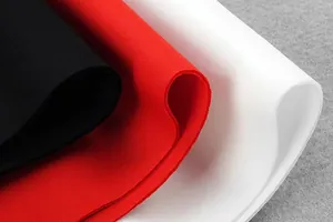 Macro detail of high-quality scuba fabric in black, red, and white colors for evening dress