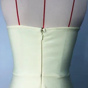 Close-up detail of the smooth back invisible zipper on a cream colored bandage dress.