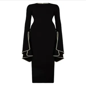 Close-up of elegant black long-sleeve evening dress with pearl neckline and flared cuffs.