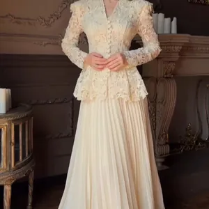 Detail view of elegant cream lace peplum top paired with matching long pleated skirt set