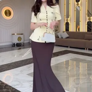 Elegant two-piece fashion set featuring a yellow floral top and dark brown maxi skirt view
