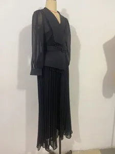 Close-up detail of a black pleated two-piece outfit with beaded fringe and sheer sleeves.