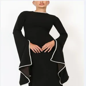 Detailed view of black evening dress featuring elegant pearl trim on flared sleeves
